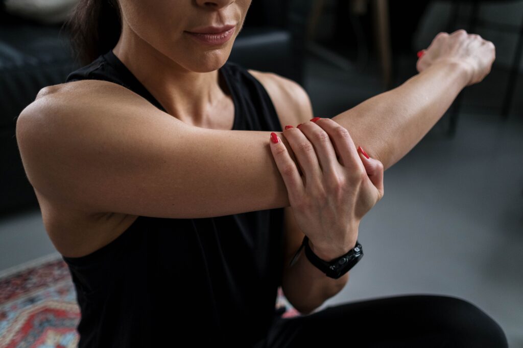 pexels-photo-7900044-7900044 Close-up of a woman stretching her arm indoors during a fitness routine.
